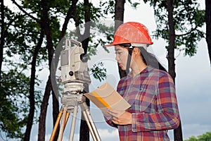 Female Surveyor or Engineer making measure on the field.