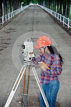 Female Surveyor or Engineer making measure on the field.