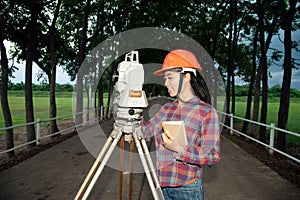 Female Surveyor or Engineer making measure on the field.