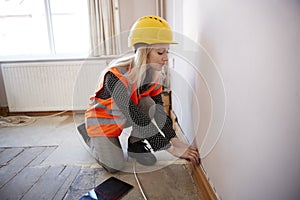 Female Surveyor In Hard Hat And High Visibility Jacket With Digital Tablet Carrying Out House Inspection photo