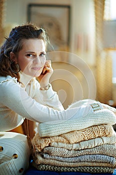 Female with sweaters in modern living room in sunny winter day
