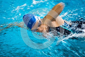 Female swimmer in an indoor swimming pool - doing crawl