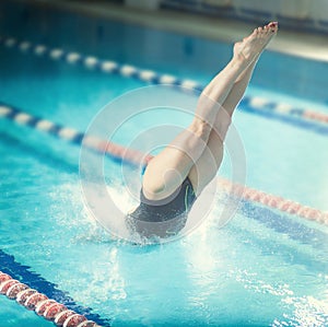Female swimmer, that jumping into indoor swimming