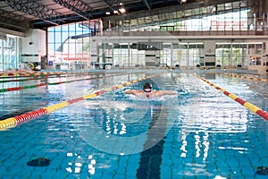 Female swimmer moving through the water performs a butterfly stroke