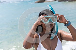 Female Swimmer Smiling And Putting On Snorkeling Goggles