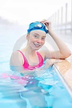 female swimmer wearing swim cap and googles looking at the camera