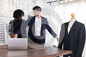 Female tailor fitting businessman for suit in tailor shop