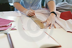 Female Tailor Making Sewing Patterns On Table