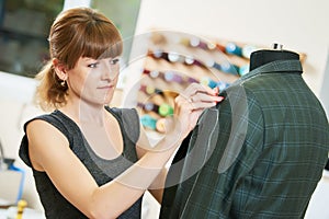 Female tailor works with male suit