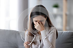Female take off glasses massaging nose bridge feeling eye strain