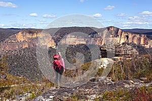 Female taking in magnificent vistas of sheer sandstone cliffs