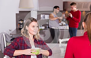 Female talking to female friend at kitchen of hostel