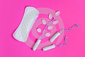 Female tampon with with cherry petals and woman gasket on a pink background. Hygienic white tampon for women