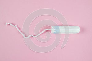 Female tampon on a pink background. Hygienic white tampon for women. Cotton swab. Menstruation