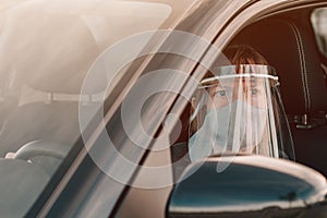 Female taxi driver with protective face mask and plastic visor