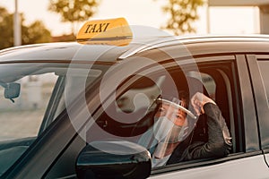 Female taxi driver with protective face mask and plastic visor photo