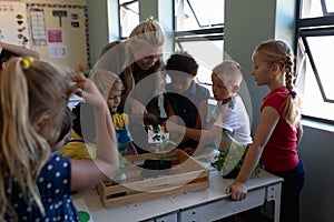 Female teacher around a box of plants for a nature study lesson in an elementary school classroom