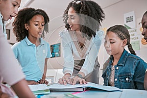 Female teacher asking student a question, children learning in classroom and sign homework in book. School for teaching