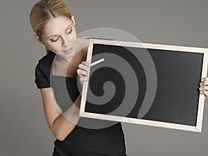 Female Teacher With Blackboard And Chalk