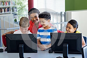 Female teacher with children during computer class