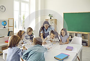 Female teacher and junior high school students have fun putting together puzzles in class.