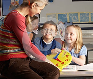 Female Teacher In Primary School Teaching Children