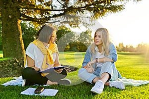 Female teacher psychologist social worker talking to teenage student on the lawn