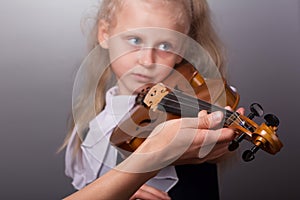 Female teacher`s hand helps a little girl to play violin