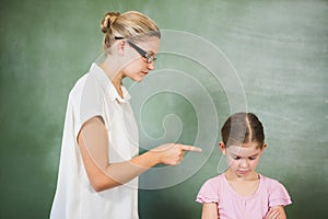 Female teacher shouting at girl in classroom