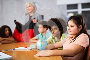 Female teacher showing german to kids in geography class