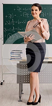 Female teacher standing in front of chalkboard