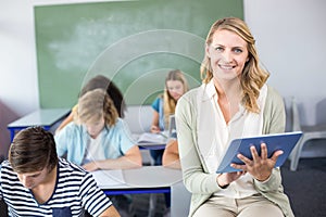 Female teacher using digital tablet in class