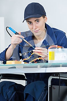 Female technican soldering electronic printed board photo