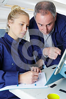 female technician completing form from information on computer screen