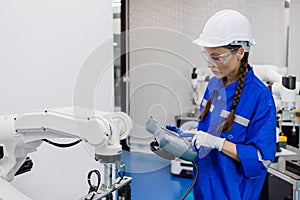 female technician engineer using remote control automation robotics at industrial modern factory. woman working at factory