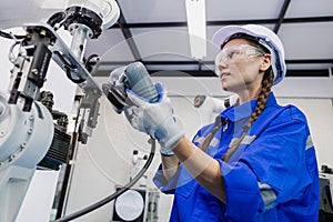 female technician engineer using remote control automation robotics at industrial modern factory. woman working at factory