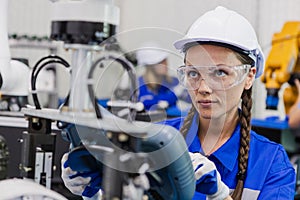 female technician engineer using remote control automation robotics at industrial modern factory. woman working at factory