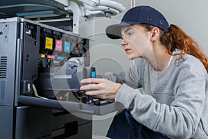 Female technician fixing printer