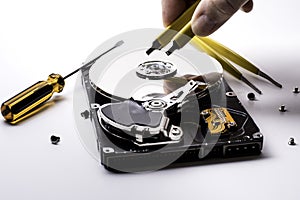 Female technician hand holding and working on  computer hard drive with screwdriver