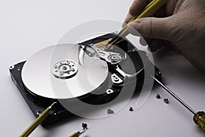 Female technician hand holding and working on  computer hard drive with screwdriver