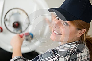 female technician repairing boiler