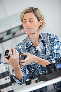 female technician repairing dslr lense