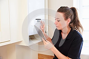 Female technician servicing boilerÃÂ using tablet computer