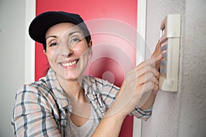 female technician sets thermostat