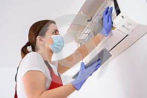 Female technician using digital tablet and repairing air conditioner