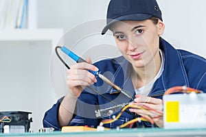 Female technician using soldering iron