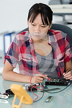 female technician using voltage meter on hard drive