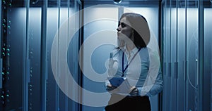 Female technician works on a tablet in a data center