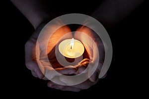 Female teen hands holding burning candle