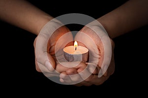 Female teen hands holding burning candle